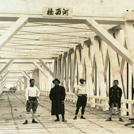 橋の前での創業者（左から3人目）
